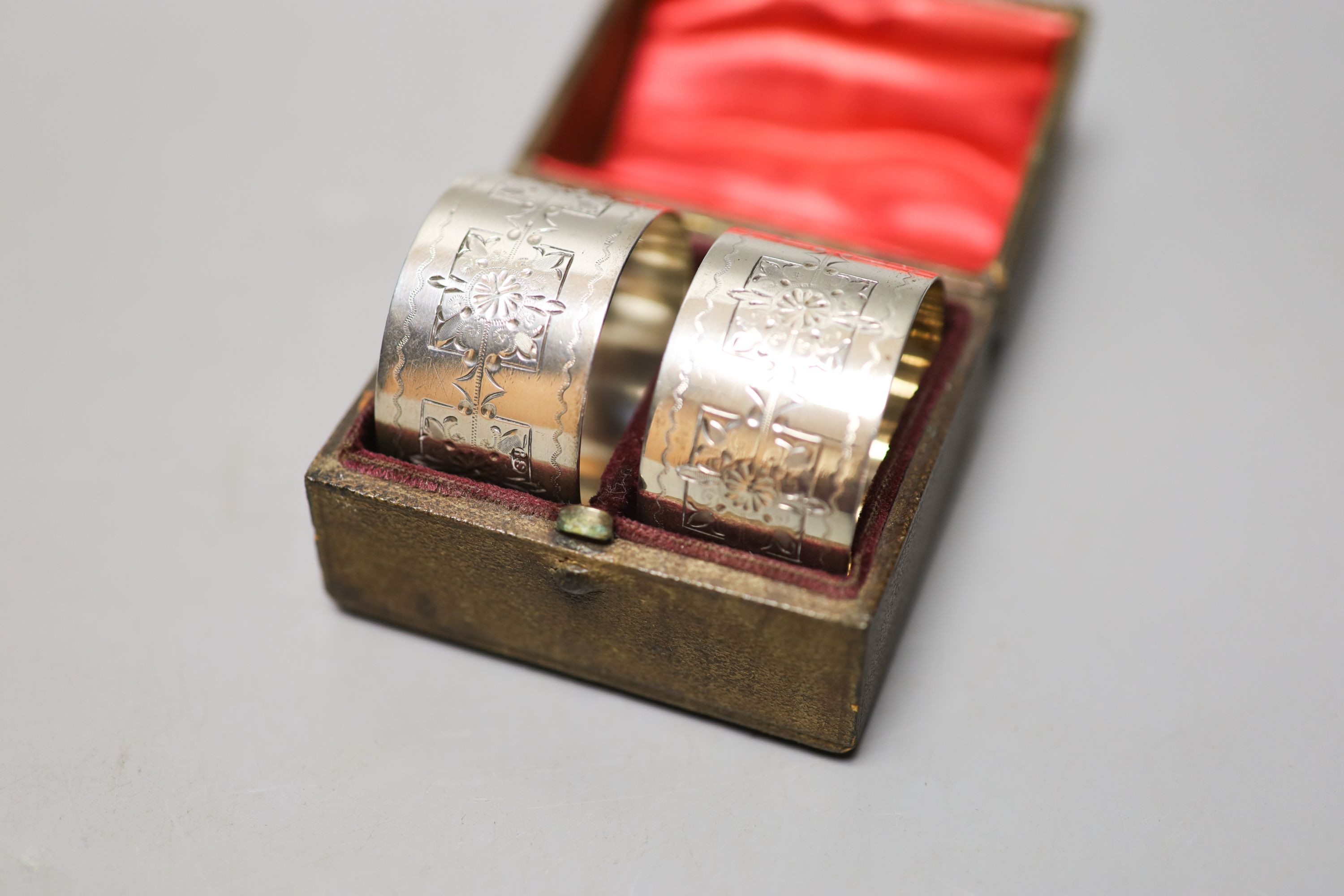 Four pairs of silver napkin rings including cased Victorian and a cased pair of silver pepperettes.